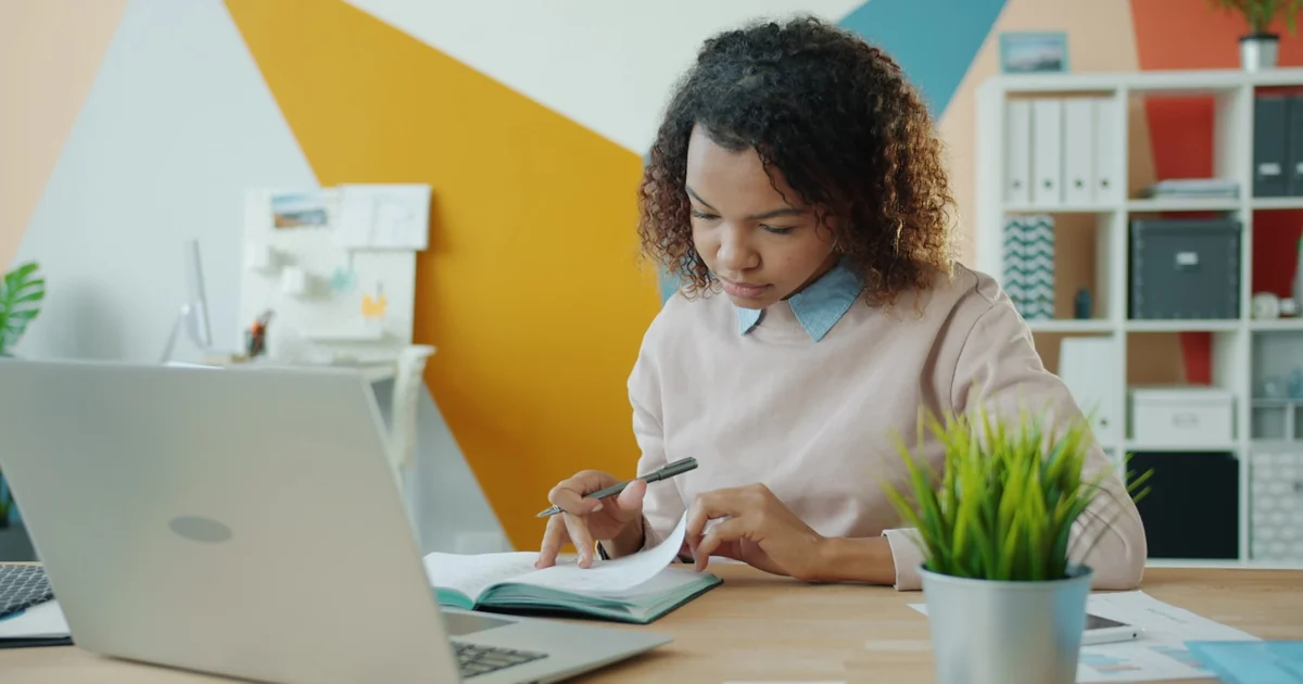 Estudiante revisando papeles y requisitos junto a su notebook antes de inscribirse